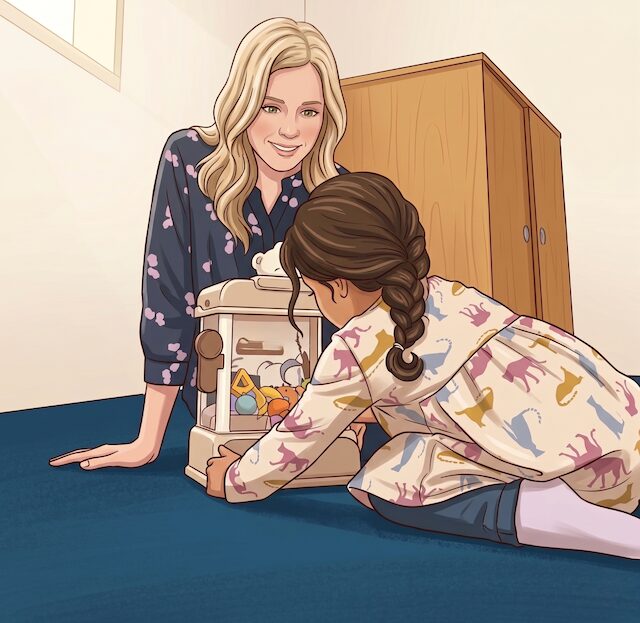 Julie working with a child on the floor